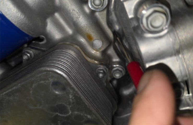 Fuga de aceite de motor entre el cárter y el adaptador del enfriador de aceite